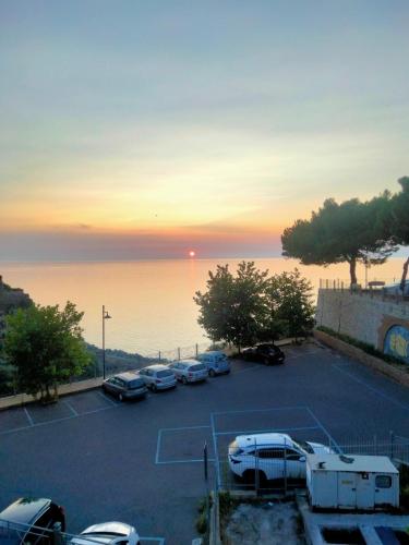 a parking lot with cars parked in front of the ocean at Loft House in Pizzo