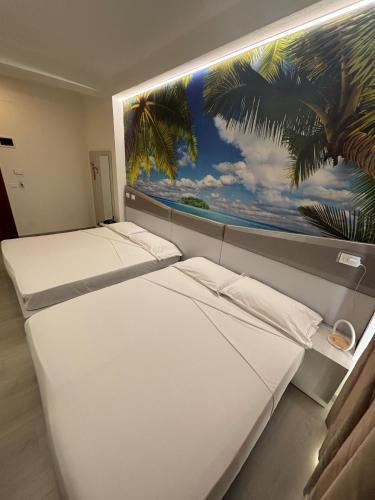 two beds in a room with a painting on the wall at Hotel Fiera Wellness & Spa in Bologna