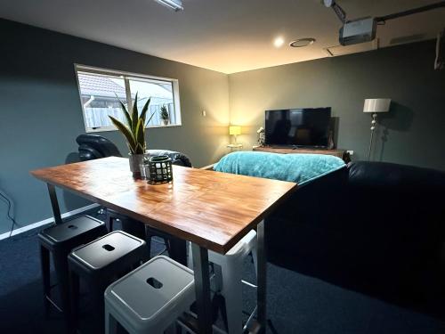 a room with a table and a bed and a bedroom at Large warm 4BRM family recharge in Halswell - Netflix, Massage chair in Halswell