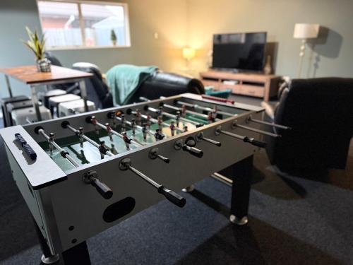 a large foosball table in a living room at Large warm 4BRM family recharge in Halswell - Netflix, Massage chair in Halswell