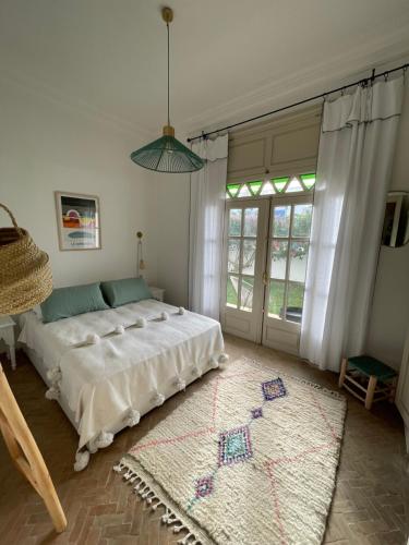 a bedroom with a bed and a large window at Maison Marine in Oualidia