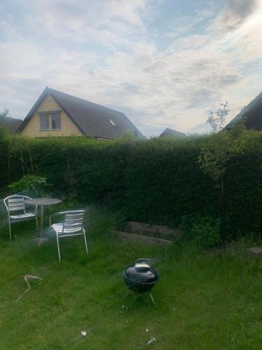 a yard with two chairs and a table in the grass at Cozy room and rooms in a town in Staffanstorp