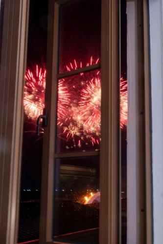 a window view of a firework display seen through a window at Jana Hotel & Apartment - Firework & Aquatopia Water Park in Phu Quoc
