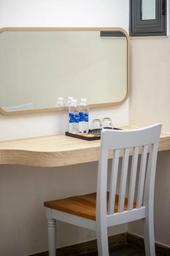 a white chair sitting next to a desk with a mirror at Jana Hotel & Apartment - Firework & Aquatopia Water Park in Phu Quoc