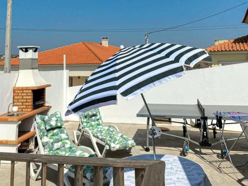 a table and chairs with an umbrella on a patio at West Country House in Lourinhã