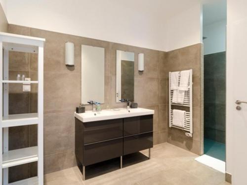 une salle de bain avec un lavabo et un miroir dans l'établissement Chateau Pech-Céleyran, à Salles-dʼAude