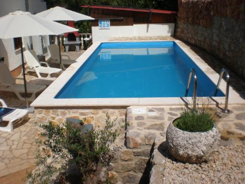 a swimming pool in the middle of a yard at Apartments Seka in Risika