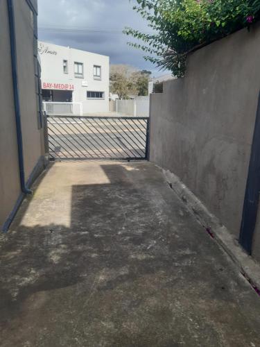 an empty alley with a fence and a building at CBS Accommodation in Mossel Bay