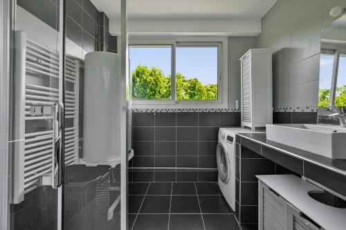 une salle de bain avec un lavabo et une machine à laver dans l'établissement Le City Mood - 2 pers - Wifi - Stade de France, à Aubervilliers