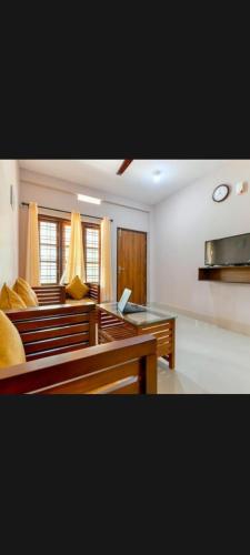 a living room with wooden benches and a table at Finenest homes kalpetta in Kalpetta