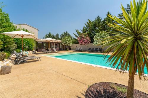 - une piscine avec un palmier à côté d'une maison dans l'établissement Bergeries Saumane, Les Lavandes, à Saumane-de-Vaucluse
