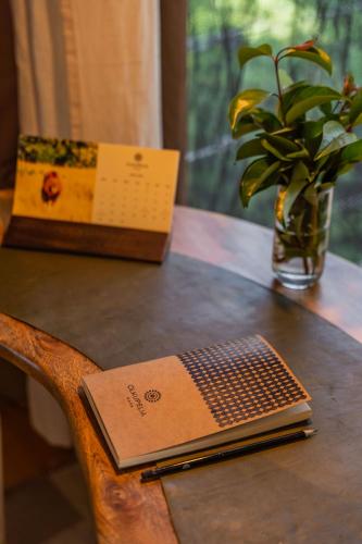 a book sitting on a wooden table with a vase at Olkupelia Mara in Talek