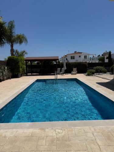 a swimming pool with blue water in a yard at Villa Porta Aurea in Ayia Napa