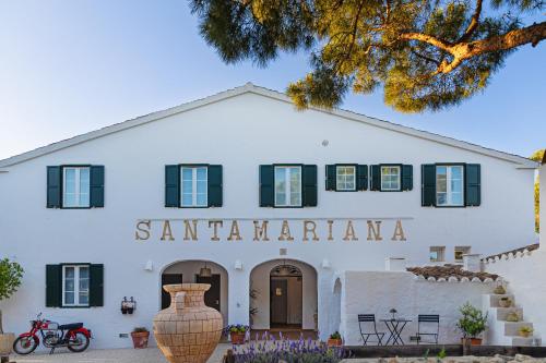 a white building with a sign that reads santanderiani at Agroturismo Santa Mariana in Alaior