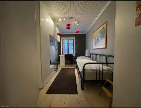 a bedroom with a bed and a desk in it at A Lovely House with A Garden in Helsinki in Siltamäki
