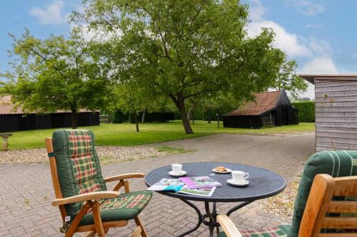 a patio table with two chairs and a table with coffee cups at Gastenverblijf Belle Rose Ruurlo in Ruurlo