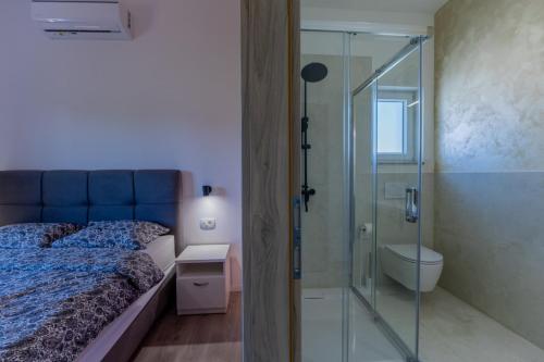 a bedroom with a glass shower stall next to a bed at E&M Forest Retreat in Svetvinčenat