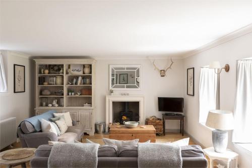 a living room with a couch and a tv at Shepherds Cottage, Pentland Hills in Nine Mile Burn