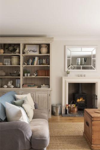 a living room with a couch and a fireplace at Shepherds Cottage, Pentland Hills in Nine Mile Burn