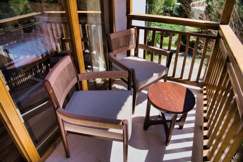 two chairs and a table on a balcony at Hotel Stendel in Deskit