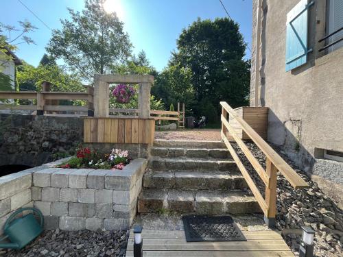 a set of stairs next to a building with a gate at Gîte Au Creux Du Moulin in Bussang