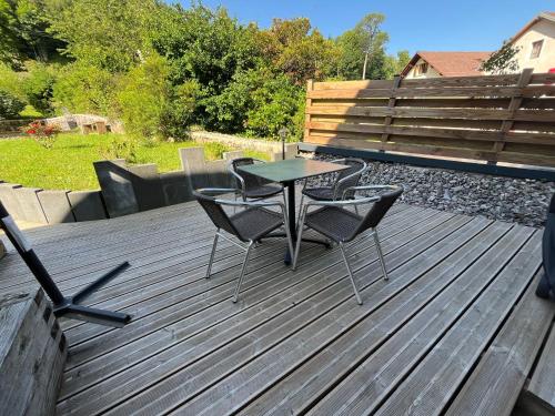 a table and chairs sitting on a wooden deck at Gîte Au Creux Du Moulin in Bussang