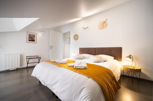 une chambre avec un grand lit avec des serviettes dessus dans l'établissement Duplex avec parking La Parenthèse Pétillante, à Épernay