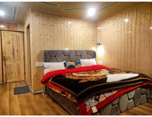 a large bed in a room with wooden walls at Hotel Sun -Shine in Pahalgām