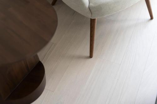 a wooden floor with a chair and a table at Gränsö Slott Hotel & Spa in Västervik