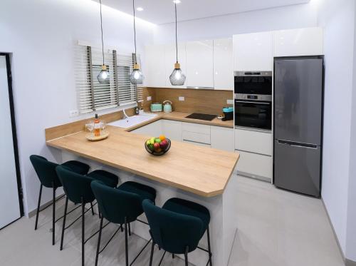 una cucina con un'isola di legno con sedie attorno di Lepanto Luxe Stay a Nafpaktos
