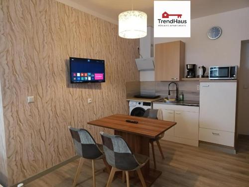a kitchen with a table and chairs and a tv on the wall at 1-ZApp "TRENDHAUS-2" Zentrum! in Hofgeismar