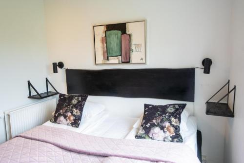 a bedroom with a bed with a black headboard at Hotel Aarslev Kro in Brabrand