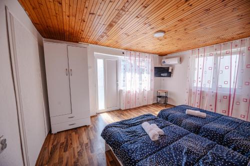 a bedroom with two beds and a wooden ceiling at Villa DukiBalo in Ohrid