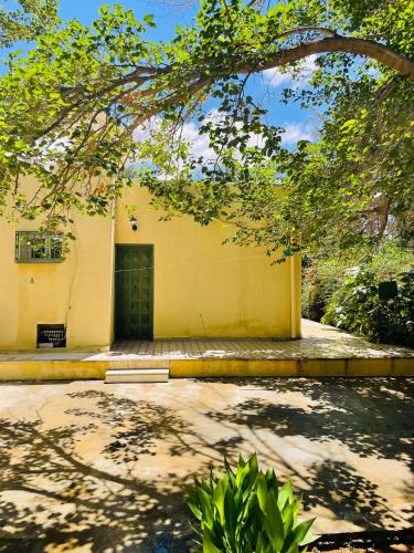 a yellow building with a door in a yard at Dar dguech in Degache