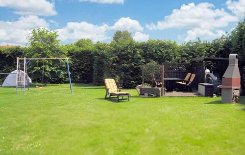 un cortile con parco giochi, sedie e altalena di Ferienwohnung Altenkirchen ad Altenkirchen