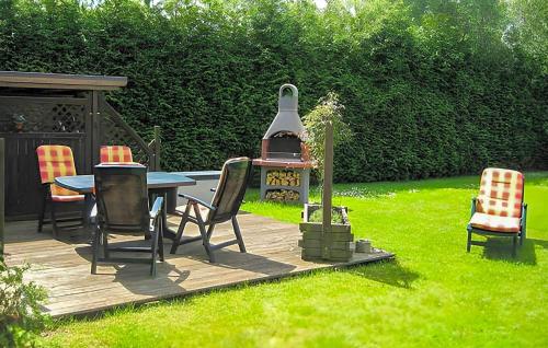 un patio con tavolo, sedie e forno di Ferienwohnung Altenkirchen ad Altenkirchen