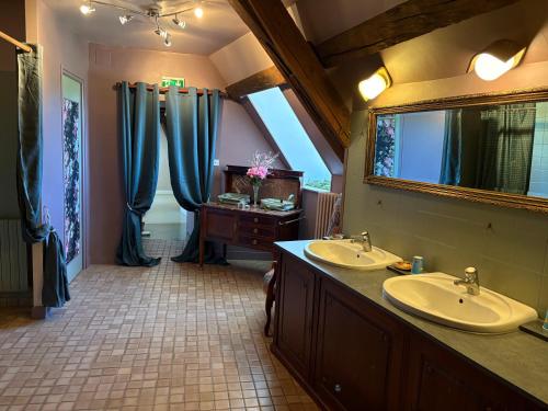 a large bathroom with two sinks and a mirror at Domaine familial du château de Ragny in Savigny-en-Terre-Plaine
