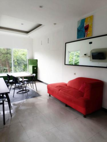 a living room with a red couch and a table at Bantal Guling Villa in Lembang