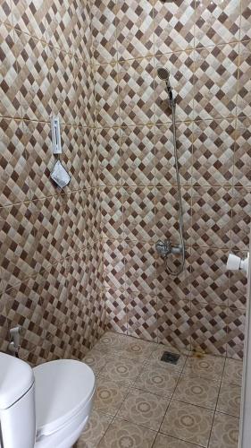 a bathroom with a shower and a toilet in it at Bantal Guling Villa in Lembang