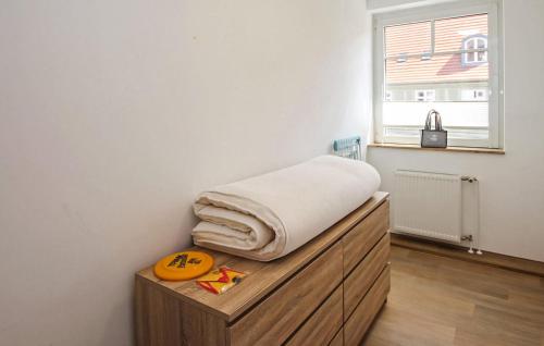 a bed with a pillow on top of a wooden dresser at Cozy Apartment In Malchow With Wifi in Malchow