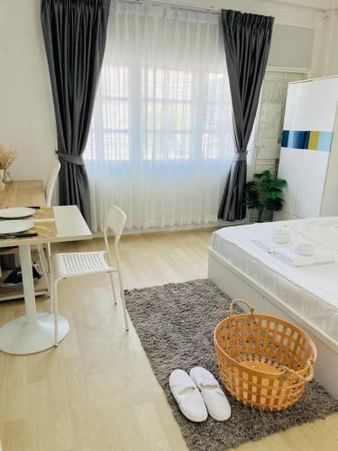 a bedroom with a bed and a table with a basket at Xin Guesthouse in Amphoe Phra Khanong