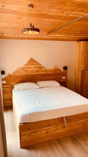 a bed in a room with a wooden ceiling at Campeggio Cianabie in Sampeire