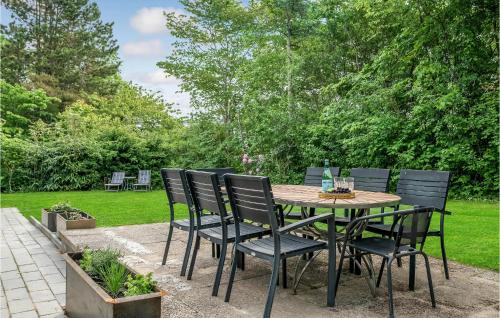 a wooden table and chairs in a garden at Holiday Home Højdevej in Vejby