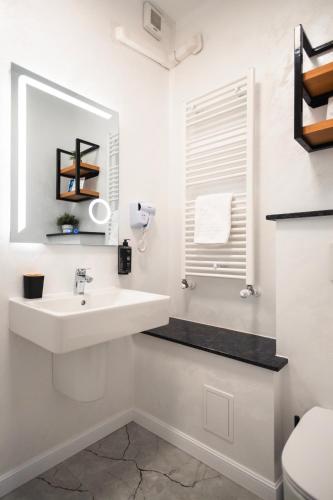 a white bathroom with a sink and a toilet at Casa Vatra Radauti in Rădăuţi