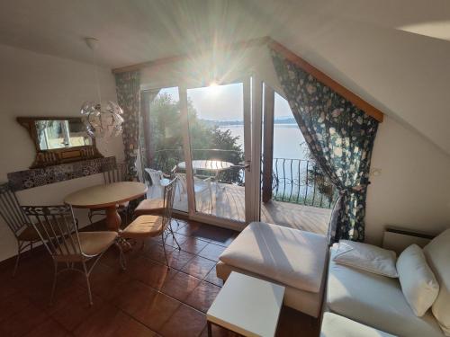 a living room with a table and a balcony at Haus am See in Sankt Kanzian
