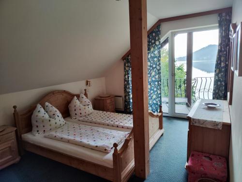 a bedroom with two beds and a sliding glass door at Haus am See in Sankt Kanzian