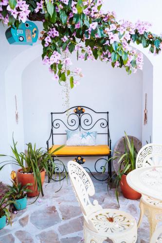 a patio with a bench and some flowers and plants at Castle House and Beach in Sines