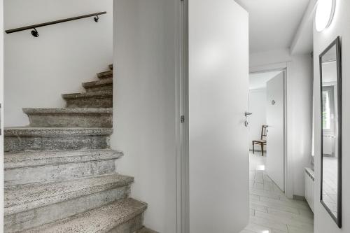 a staircase in a white room with a glass door at Residenza Quadrifoglio in Casalzuigno