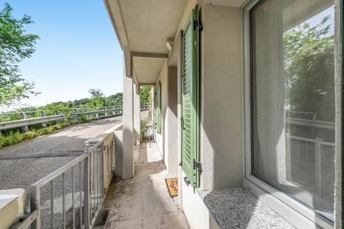 a balcony with a green door and a street at Residenza Quadrifoglio in Casalzuigno