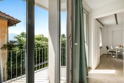 a room with a balcony with sliding glass doors at Residenza Quadrifoglio in Casalzuigno